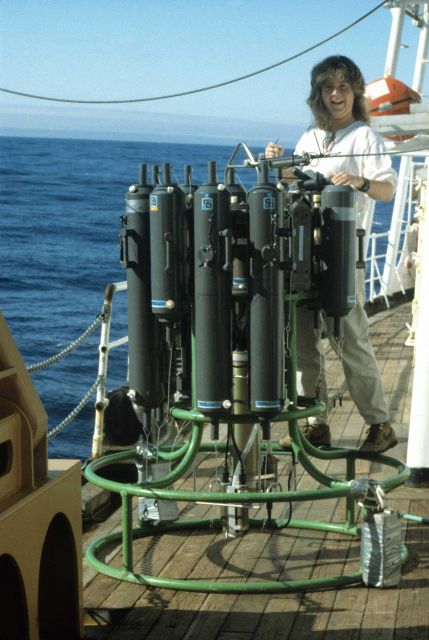 A scientist prepares a CTD rosette, with bottles to collect seawater samples. Picture