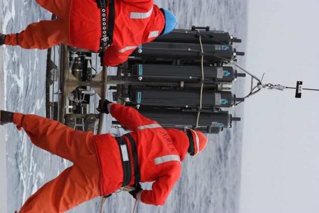 AMLR crew members lower equipment into the frigid ocean. Picture