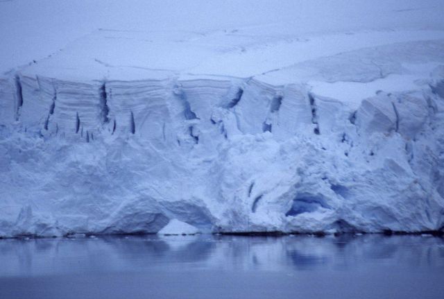 The NOAA Ship R/V Surveyor steams north past an iceberg and Elephant Island (left). Picture