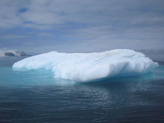 An iceberg, with most of its mass clearly visible underwater. Picture