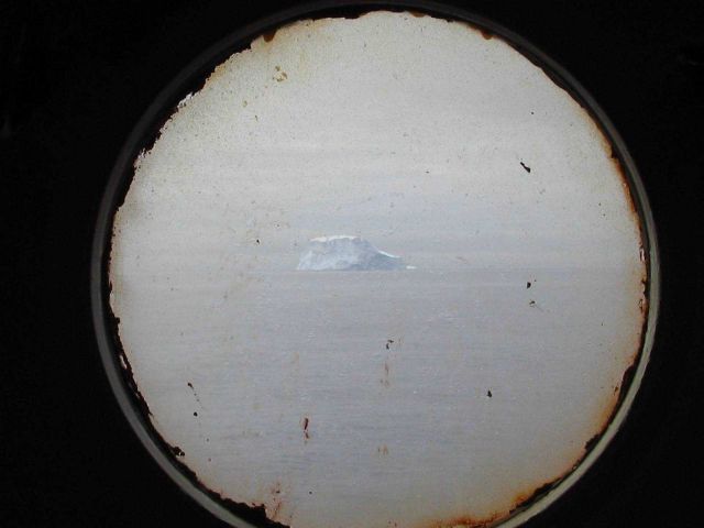 An iceberg seen through the port hole of the R/V Yuzhmorgeologiya. Picture