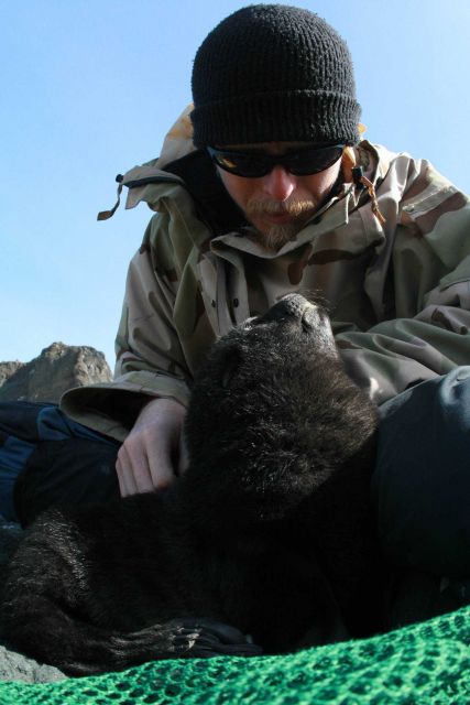 AMLR biologist Kevin Pietrzak with a fur seal pup. Picture