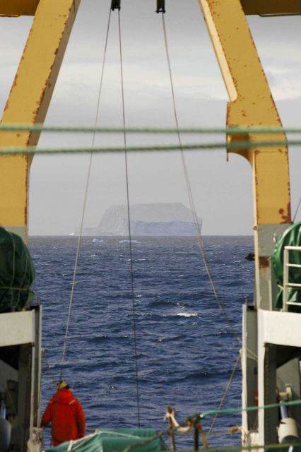 A scientist looks at an iceberg from the aft deck of the R/V Yuzhmorgeologiya. Picture