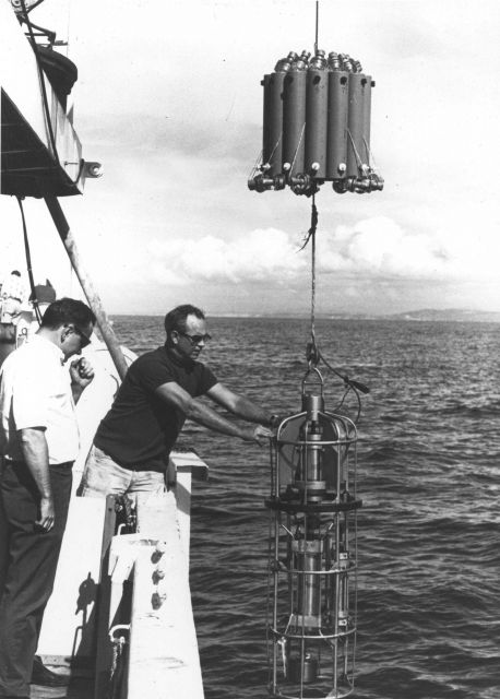 Deploying an early model STD or CTD instrument with water sample bottles above. Picture
