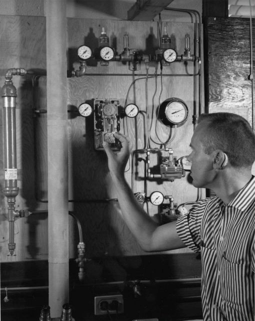 James Delaney, fishery biologist, setting control device for delivery of sea water at preset temperature and salinity levels Picture