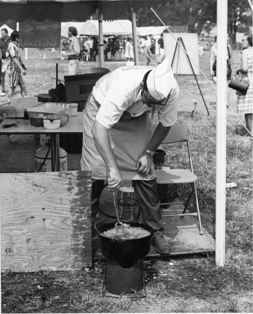 Leaning over the cook pot frying catfish Picture
