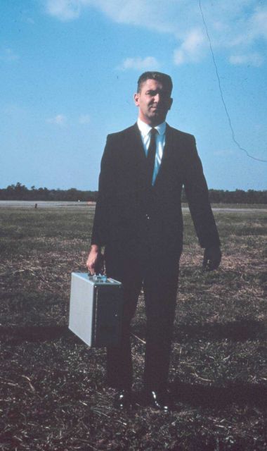 Larry Schenkat, Chief of Timing Section, with a portable quartz crystal clock Picture