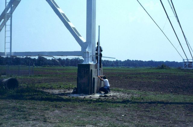 Rod man and level rod on overhead cable support anchor. Picture
