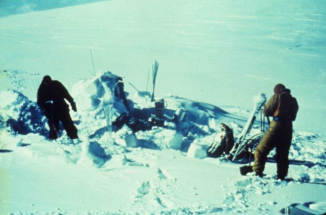 Digging out snow to find the mark for observing an astro station in winter. Picture