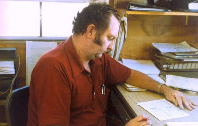 Chief of leveling party, Dan Frazier, working in the office. Picture