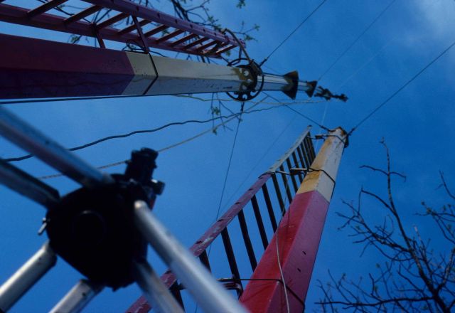 Using vertical collimator to center equipment at top of left-most pole over survey mark. Picture