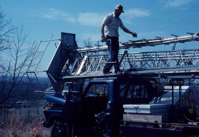 Leonard Bergman with piece of observing cage in hand preparing TMOT for erection. Picture