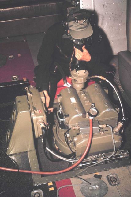 Aerial photographer in unpressurized cabin of NOAA de Havilland Buffalo breathing with assistance of oxygen mask, operating Wild RC-8 camera. Picture