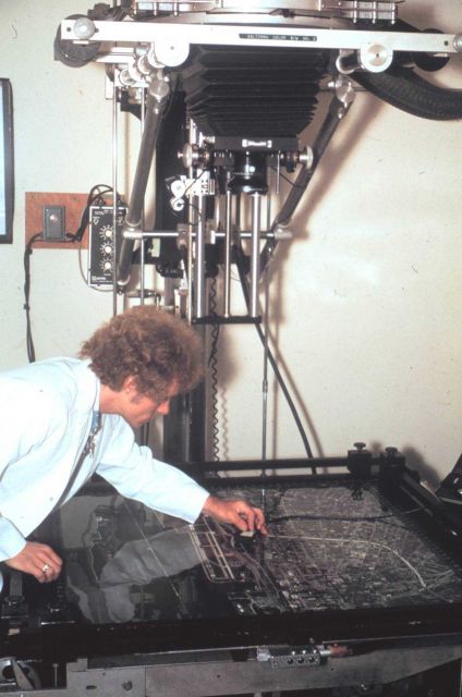 Harvey Carlson operating a photo enlarger at photo processing facility on first floor of Herbert Clark Hoover Building (Commerce Building.) Picture