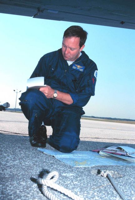 Lieutenant Commander Greg LaMontagne planning aerial photographic mission on Rockwell Turbo Commander N53RF. Picture
