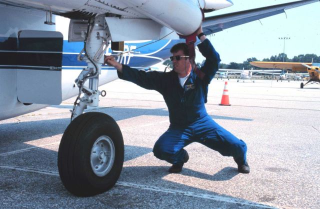 Lieutenant Commander Greg Lamontagne taking care of details that make for safe flights on Rockwell Turbo Commander N53RF. Picture