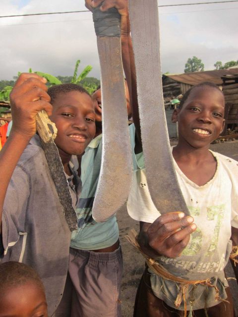 Kids from local Sao Tomean fishing village displaying their machetes Picture