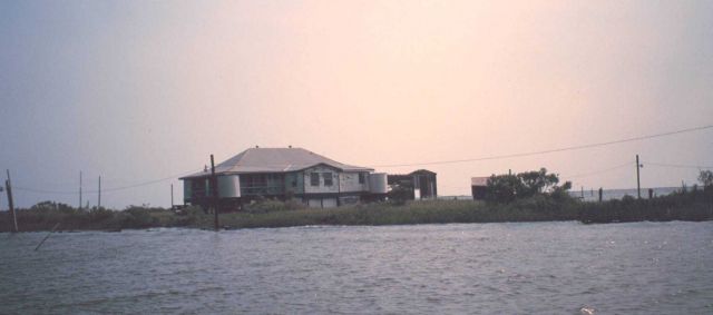 Hunting and fishing camp built on stilts - accessible only by boat although power lines have been run across the marsh. Picture