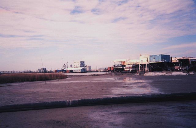 The Greenhill/East Timbalier pipe depositing dredge material in foreground -- Greenhill Petroleum facility on East Timbalier Island in background Picture