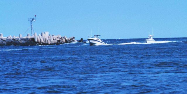 Recreational fishing boats passing the jetties at Manasquan Inlet Picture