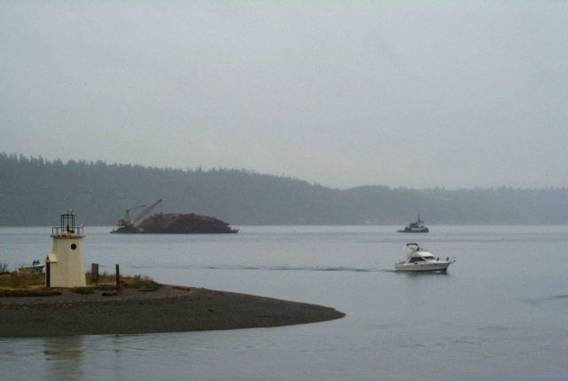 Looking past the spit at Gig Harbor to a barge-load of pine bark headed for to Steilacoom. Picture