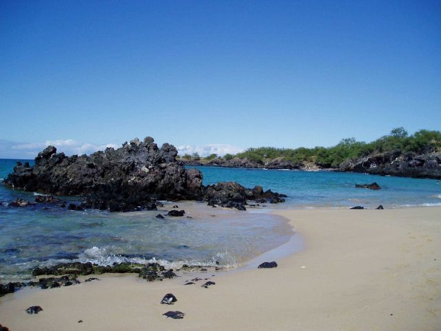 Lava rock and white sand on a quiet cove. Picture