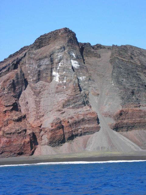 Interior structure of an eroded volcanic cone where it meets the sea. Picture