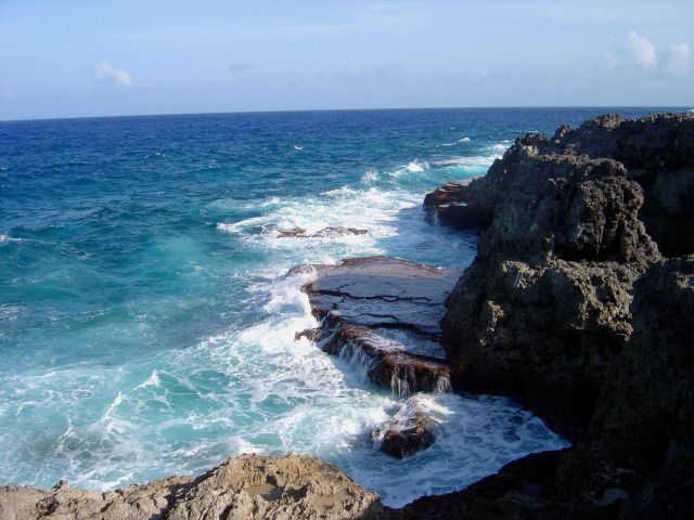Sea, foam, sky, and coral rock meet on the Guam coastline. Picture