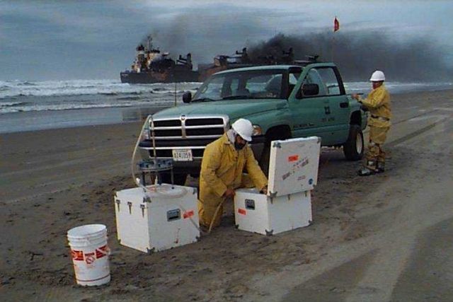 Setting up equipment to sample oil spill near grounded vessel. Picture