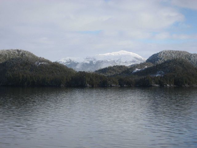 A sprinkling of snow at water level with mountains covered at higher elevations Picture