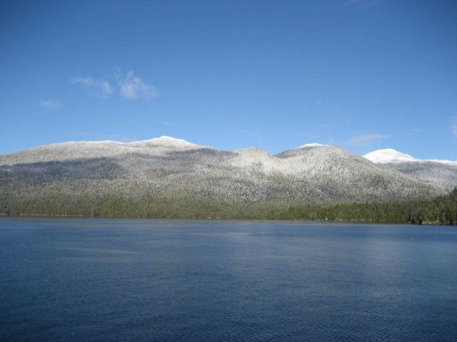 A sprinkling of snow at water level with mountains covered at higher elevations Picture