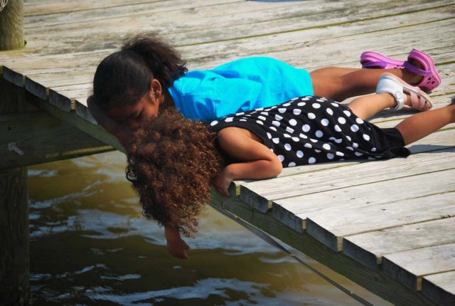 Young ladies exploring the bay from a pier. Picture