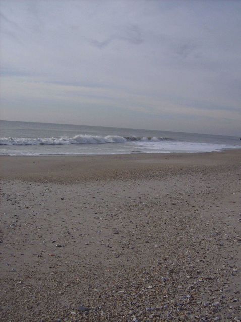 Waves washing the shores of Cape May on a deserted winter beach. Picture