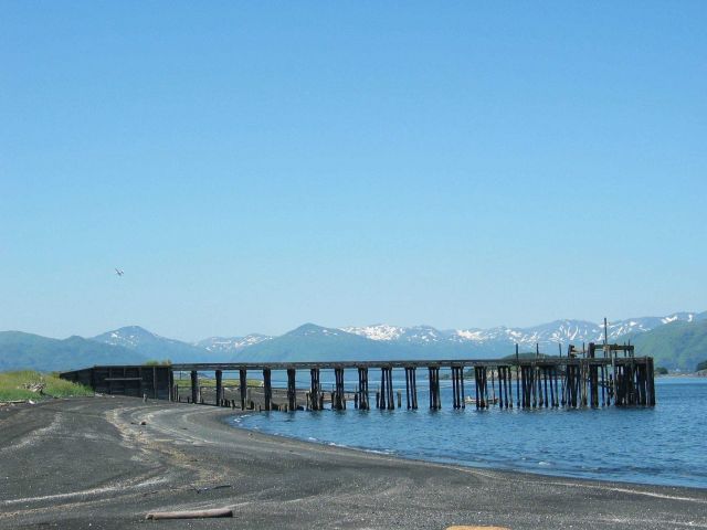Black sand and cobble beach on Kodiak Island with pier at low tide Picture