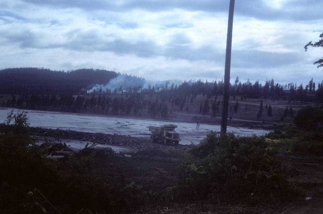 Burning brush on hillside, dump truck filling in tidal wetland area. Picture