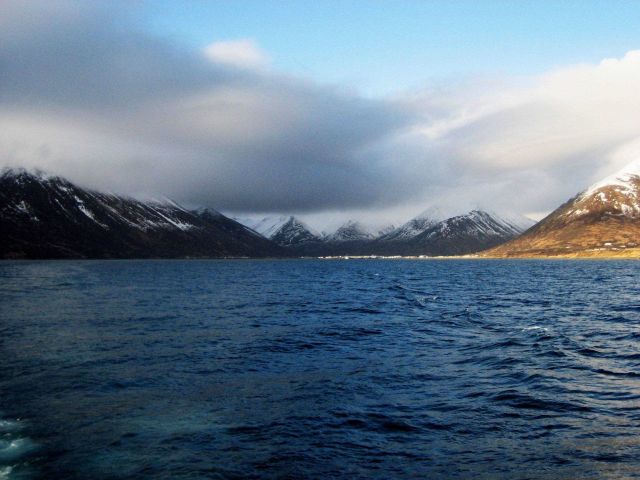 Departing King Cove with cloud shrouded, snow covered mountains in distance. Picture