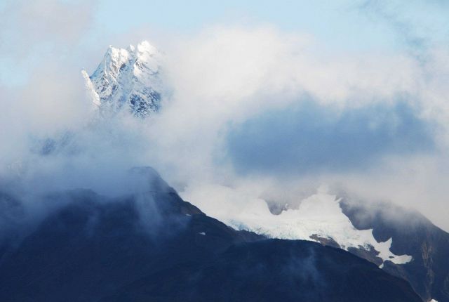 A magnificent mountain peak peeking through the clouds. Picture