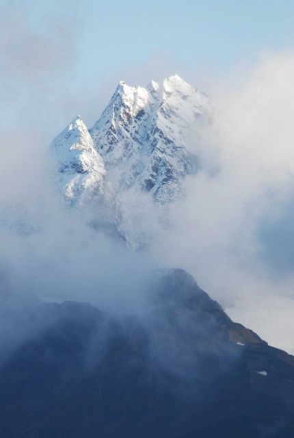 A magnificent mountain peak peeking through the clouds. Picture