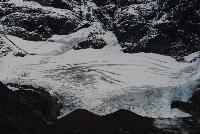 Crevasses and what appears to be a collapse feature in the center of a glacier located in the Johns Hopkins Inlet area. Picture