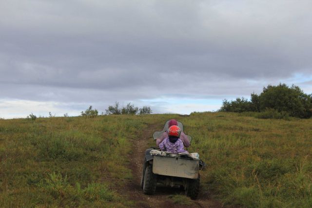 Mother and daughter going to harvest blueberries on the family ATV. Picture
