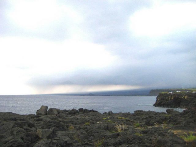 Volcanic cliffs with wind farm in the distance. Picture