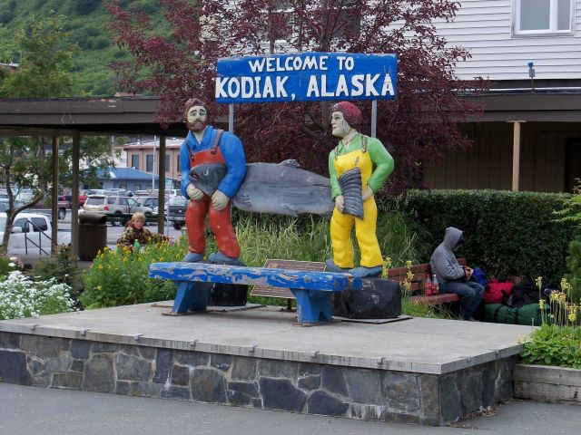 Fishermen with Paul Bunyanesque size salmon greet visitors to Kodiak. Picture