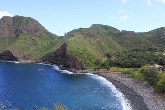 A rural settlement along the Maui coast with a cobble beach lining a quiet cove. Picture