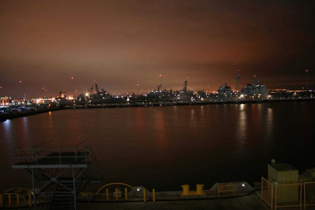 The lights of San Diego silhouette naval ships at 32nd Street Naval Base. Picture