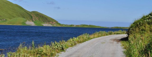 A gravel road running along the shoreline on a clear sunny day. Picture