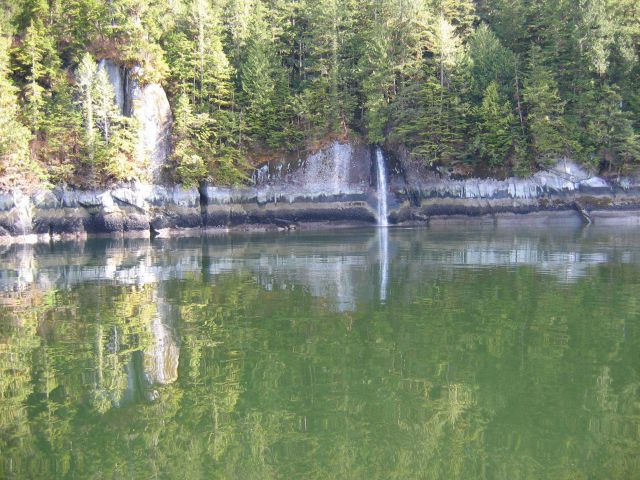 Horizontal strata on the shoreline and reflections in the still waters of Ernest Sound Picture