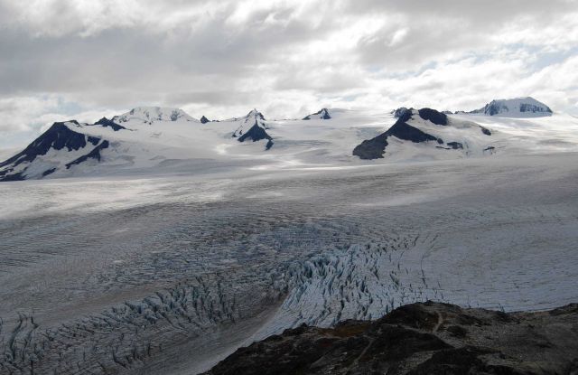 Highly crevassed glacier and surrounding mountain peaks. Picture