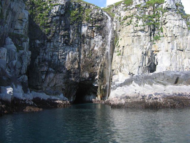 A cheerful little waterful entering the sea near a sea cave on Little Koniuji Island. Picture