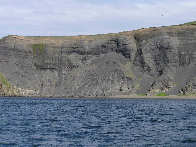 Soft sedimentary rock cliffs, probably volcanic ash, eroding into the sea in the Shumagin Islands. Picture