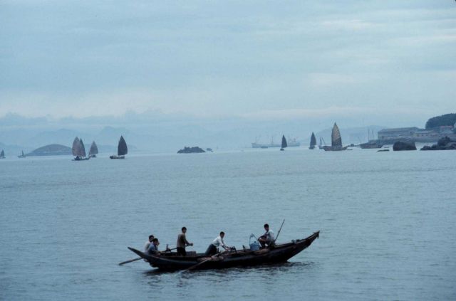 Rowed fishing vessel with sampans in distance Picture